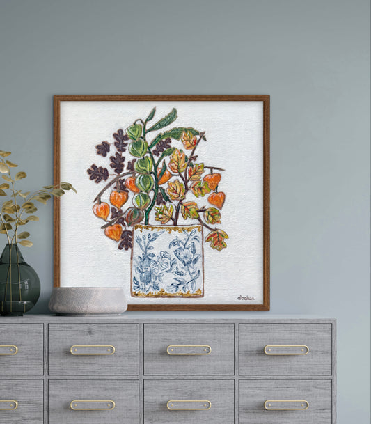 A delicate still life featuring vibrant orange and green lantern flowers arranged in a blue-and-white porcelain vase.