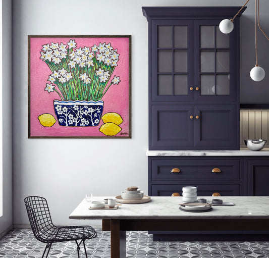 A whimsical painting of paperwhites in a blue and white floral vase surrounded by lemons against a bright pink background.
