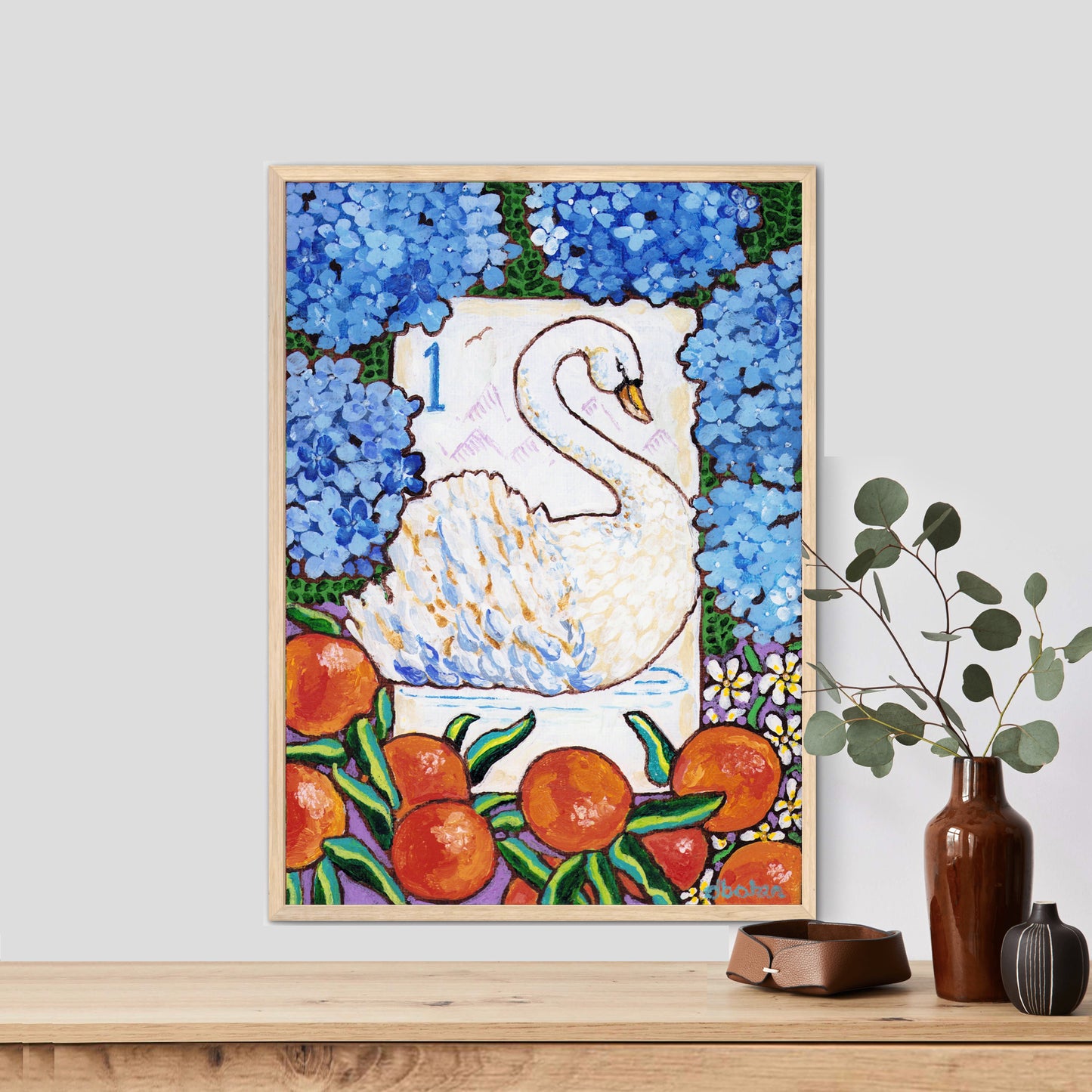 Framed artwork of a swan bird bam Mahjong tile among flowers and fruits on a wall with decorative books and plants below. This art is perfect for a Mahjong game room.