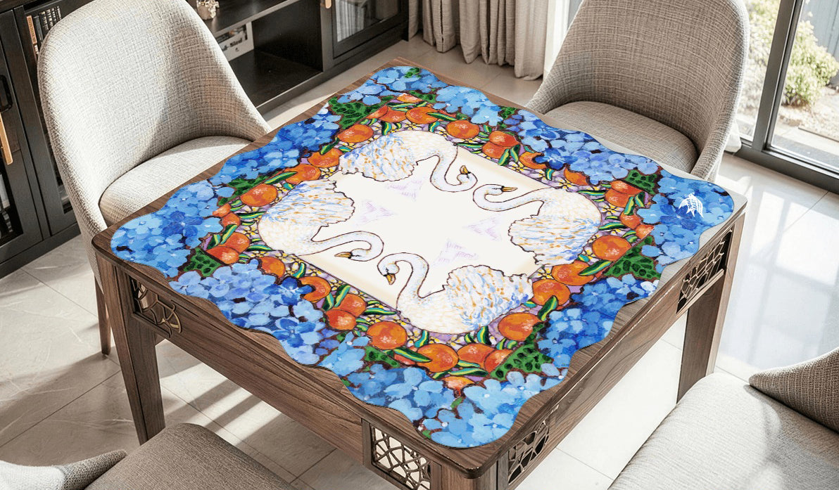 A scalloped mahjong mat featuring an original painting of swans, oranges, orange blossoms and hydrangeas.