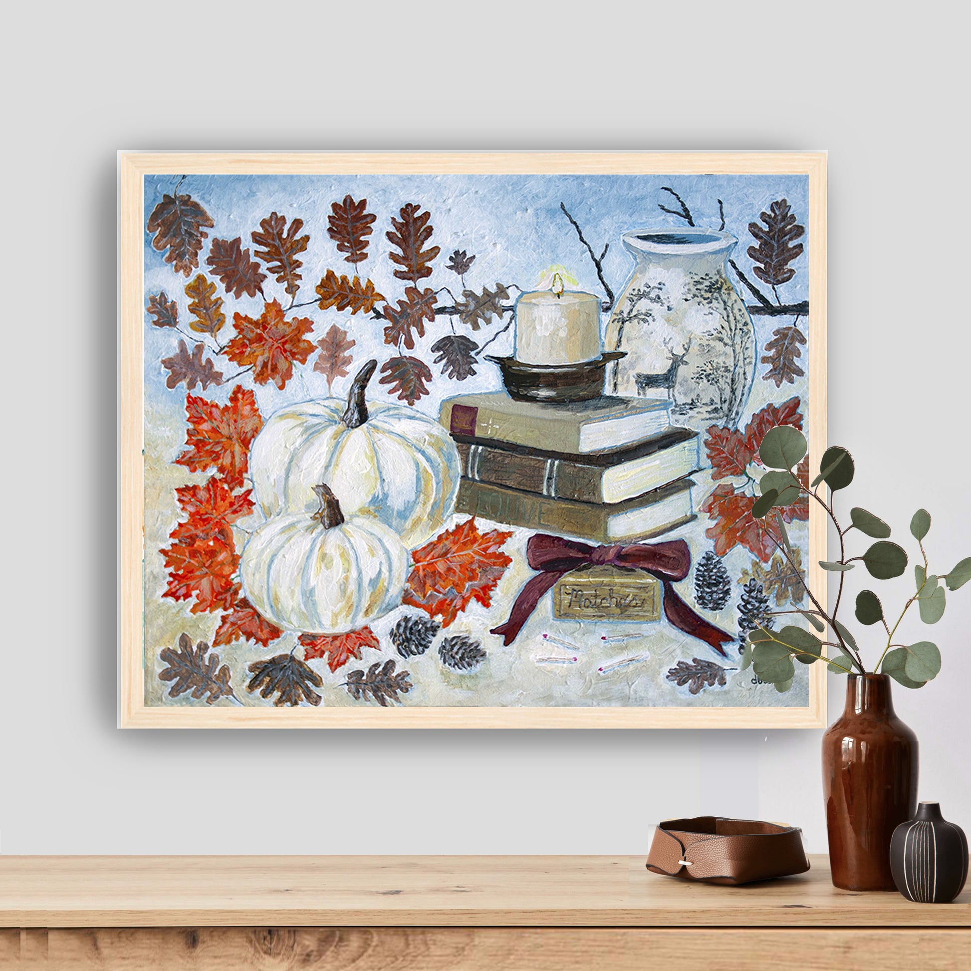 A painting of a cozy autumn still life featuring white pumpkins, vintage books, a red velvet bow and warm fall leaves. A perfect rustic accent for your home decor.