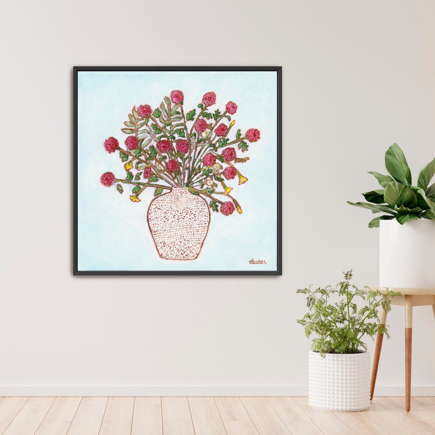 Framed artwork of a red dahlia floral arrangement on a light blue background, with a white patterned vase and plants on a wooden surface.
