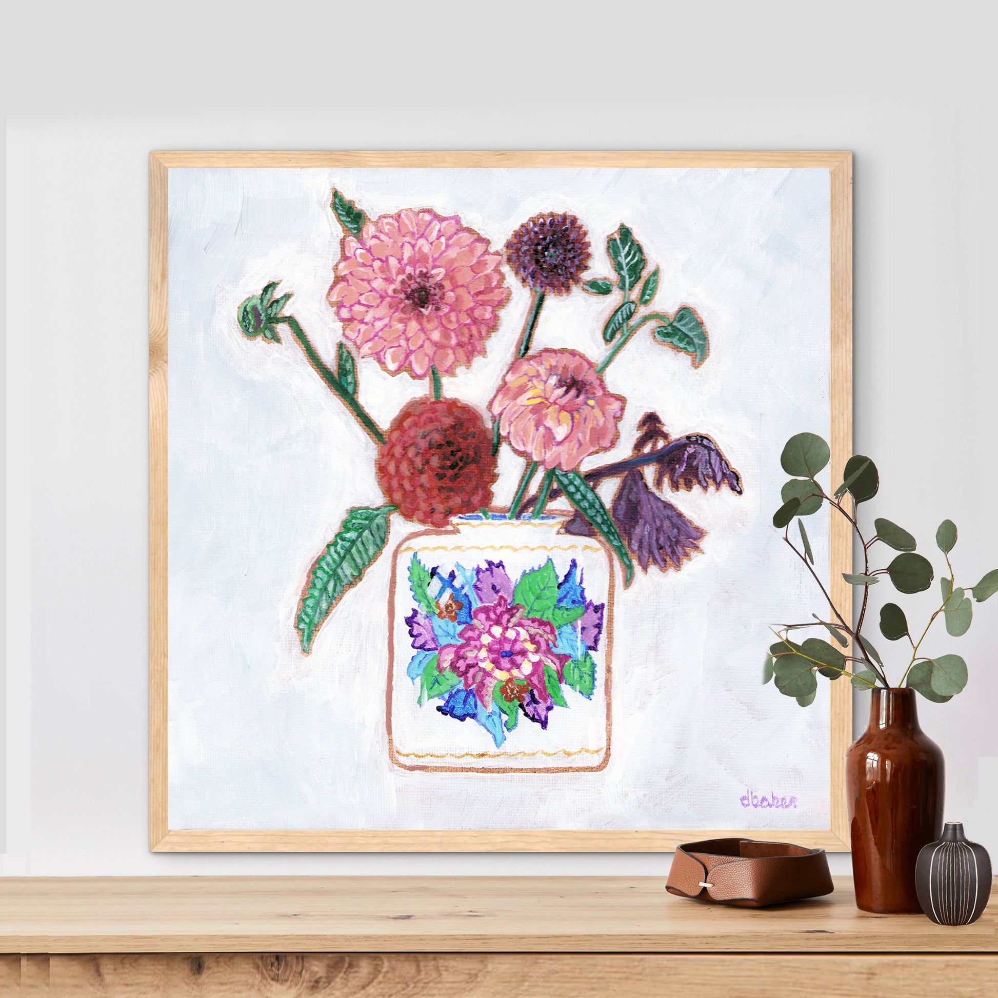 Vibrant dahlias bloom from a classic tobacco leaf vase, blending bold color, texture, and tradition in a modern still life