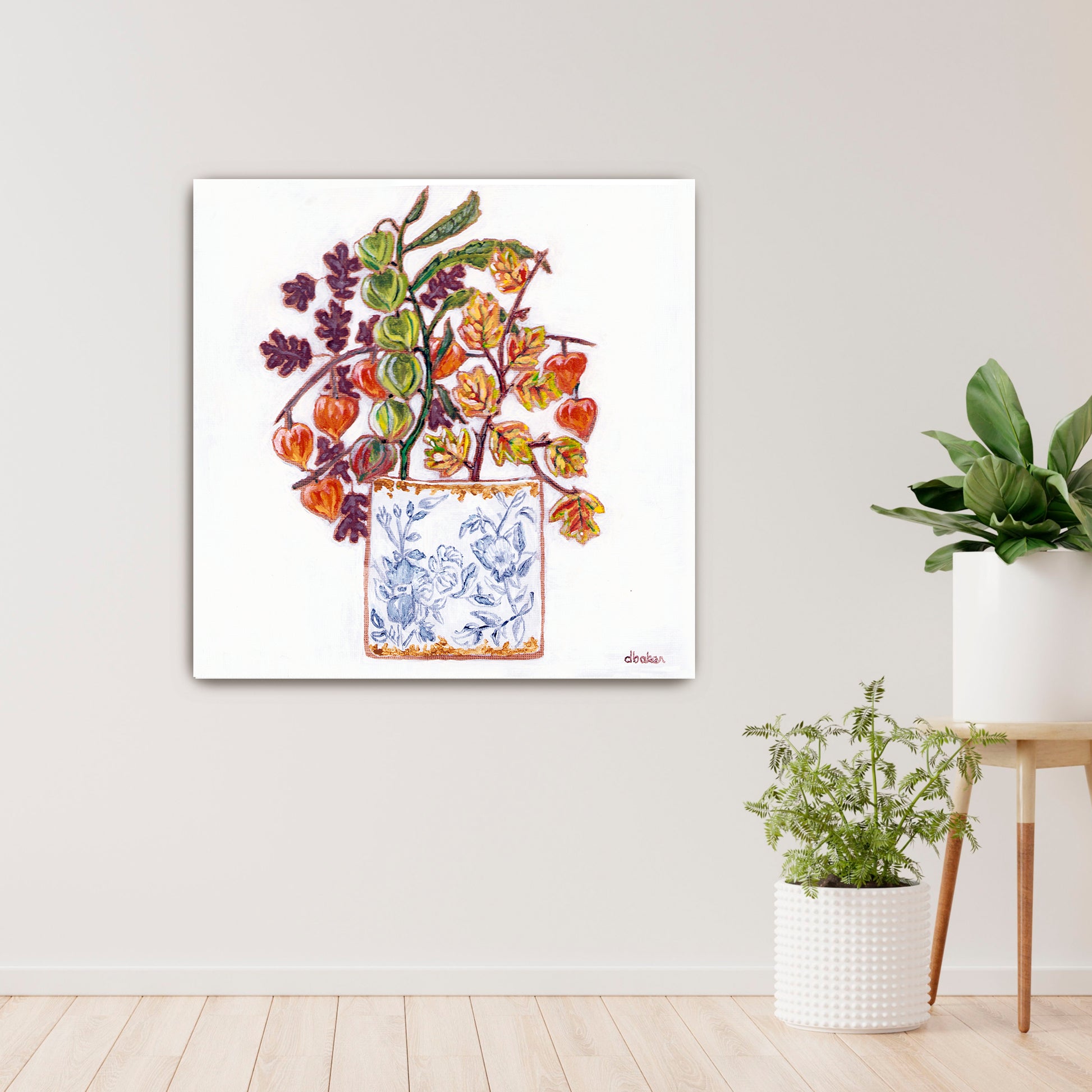A delicate still life featuring vibrant orange and green lantern flowers arranged in a blue-and-white porcelain vase.