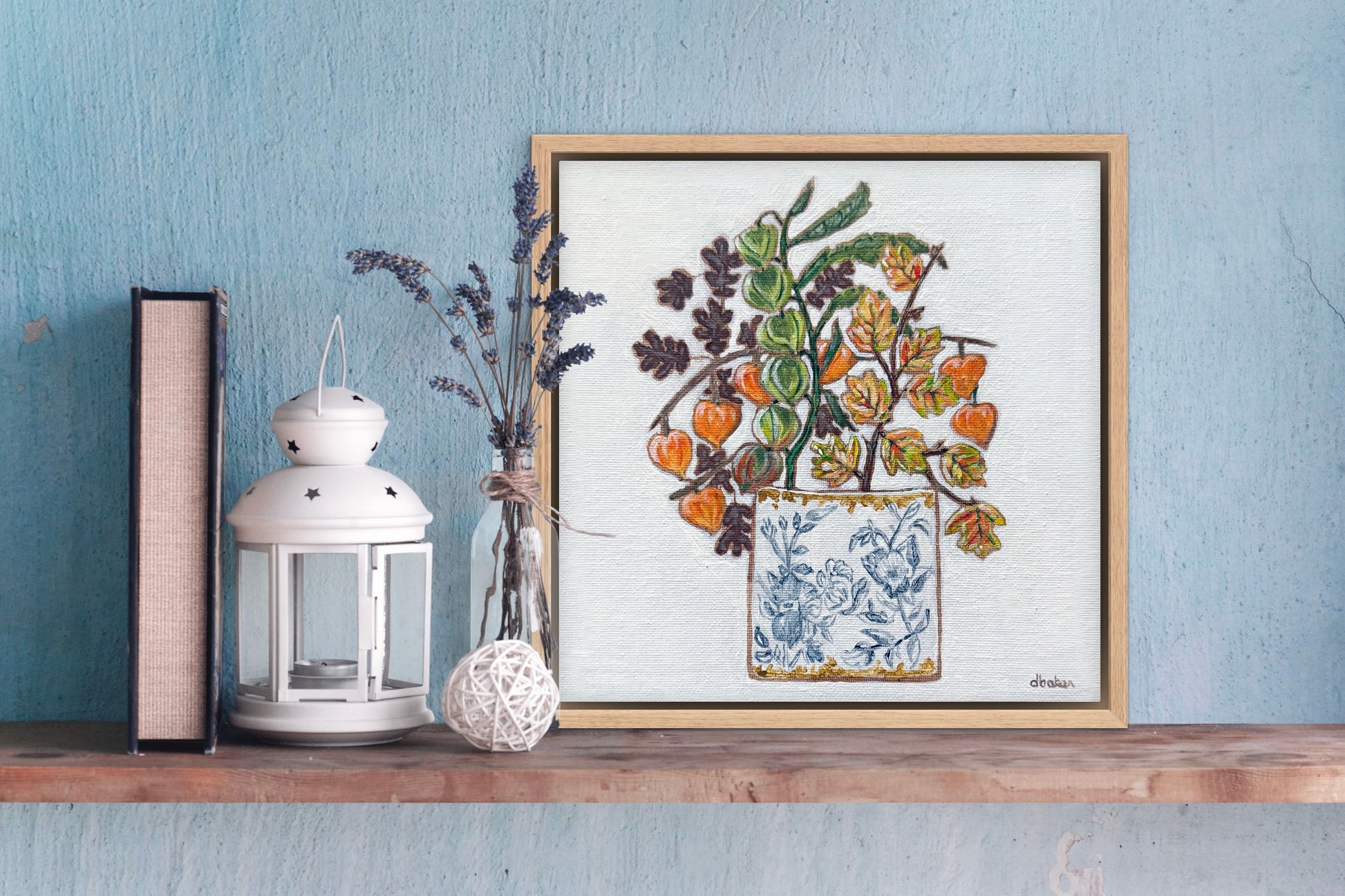 A delicate still life featuring vibrant orange and green lantern flowers arranged in a blue-and-white porcelain vase.