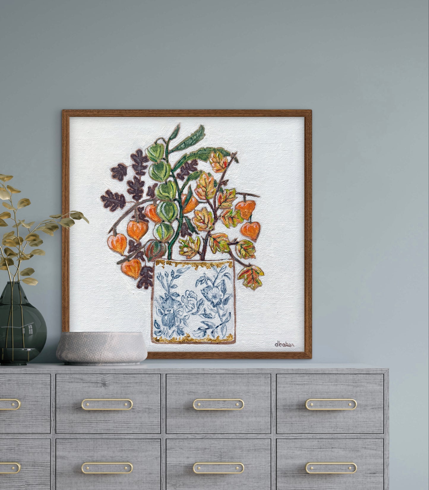 A delicate still life featuring vibrant orange and green lantern flowers arranged in a blue-and-white porcelain vase.