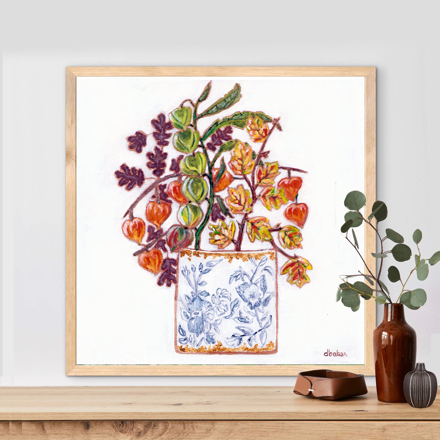 A delicate still life featuring vibrant orange and green lantern flowers arranged in a blue-and-white porcelain vase.