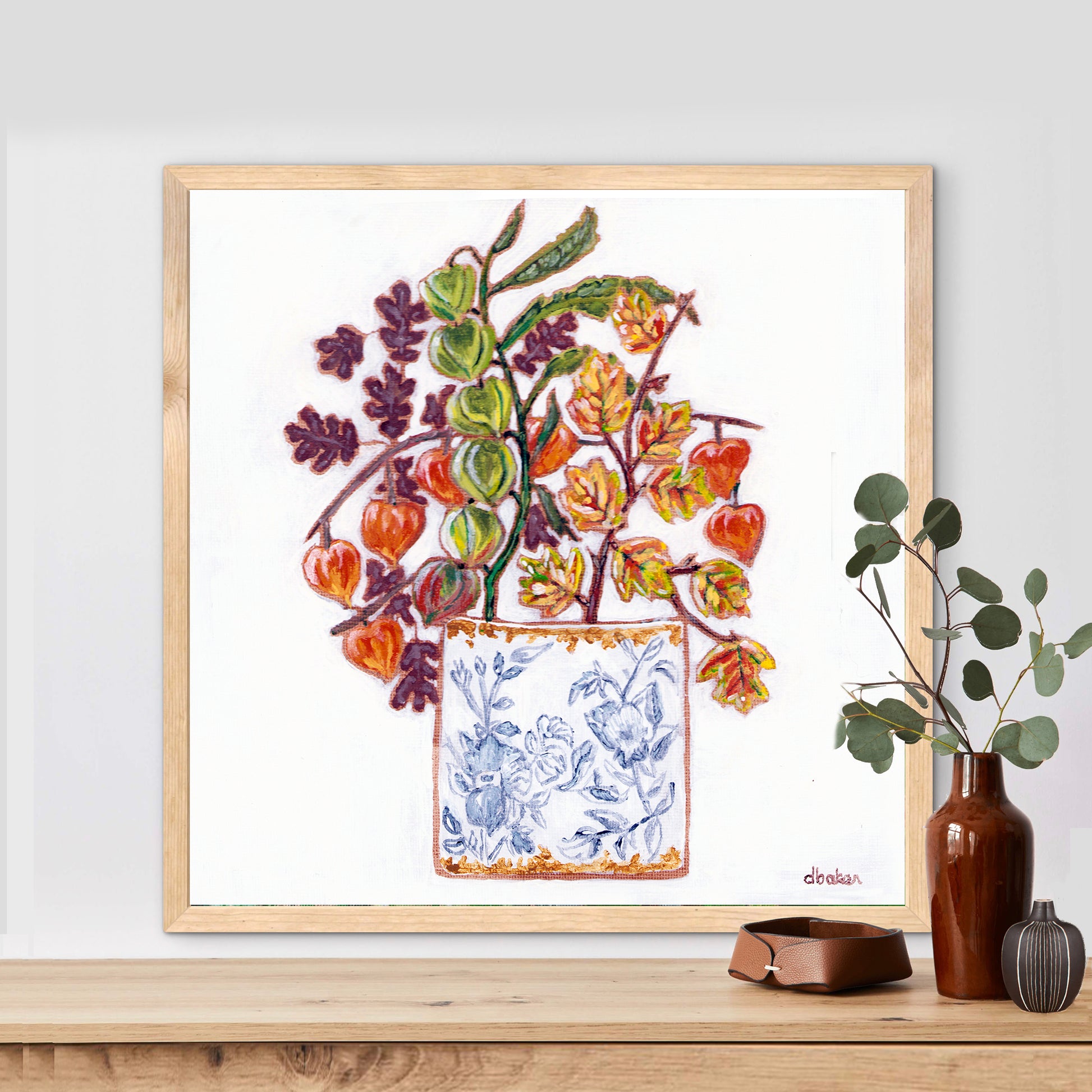 A delicate still life featuring vibrant orange and green lantern flowers arranged in a blue-and-white porcelain vase.