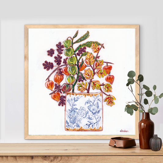 A delicate still life featuring vibrant orange and green lantern flowers arranged in a blue-and-white porcelain vase.