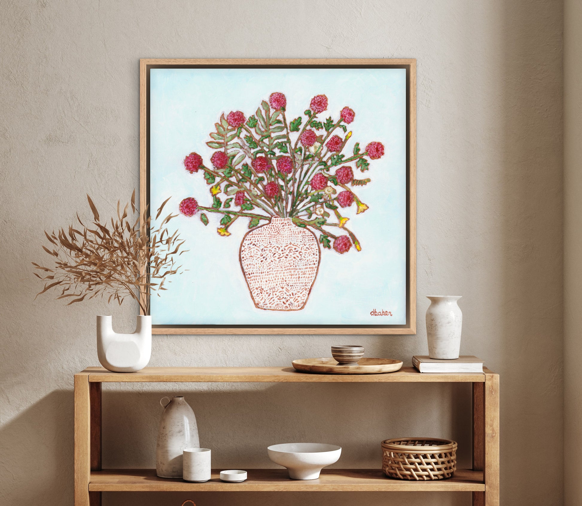 Framed artwork of a red dahlia floral arrangement on a light blue background, with a white patterned vase and plants on a wooden surface.