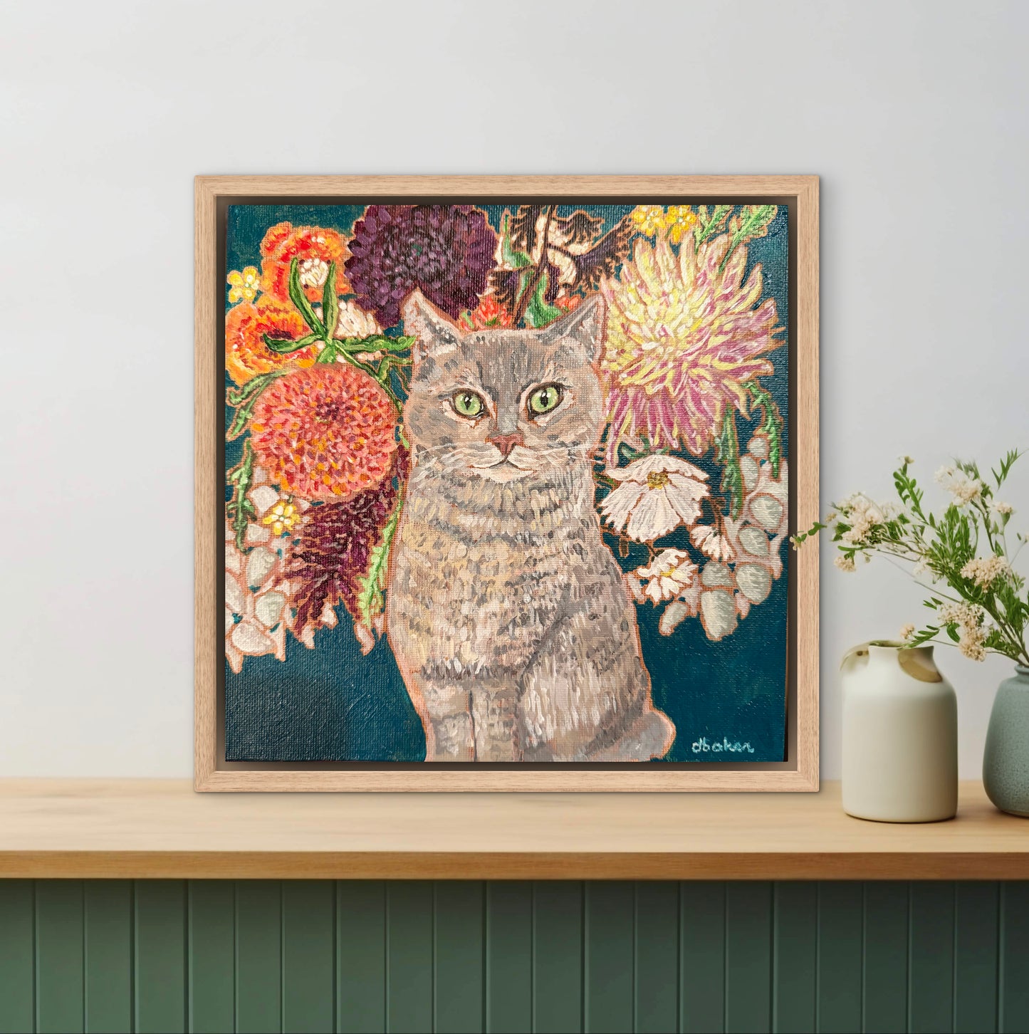 This painting is a loving portrait of Moses my gray cat shown sitting calmly in front of a rich bouquet of flowers including vibrant dahlias.
