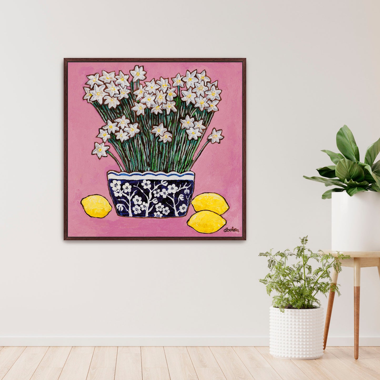 A whimsical painting of paperwhites in a blue and white floral vase surrounded by lemons against a bright pink background.