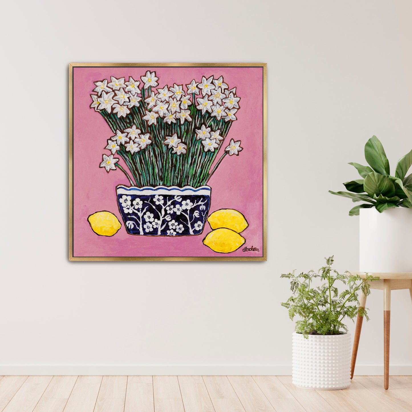 A whimsical painting of paperwhites in a blue and white floral vase surrounded by lemons against a bright pink background.