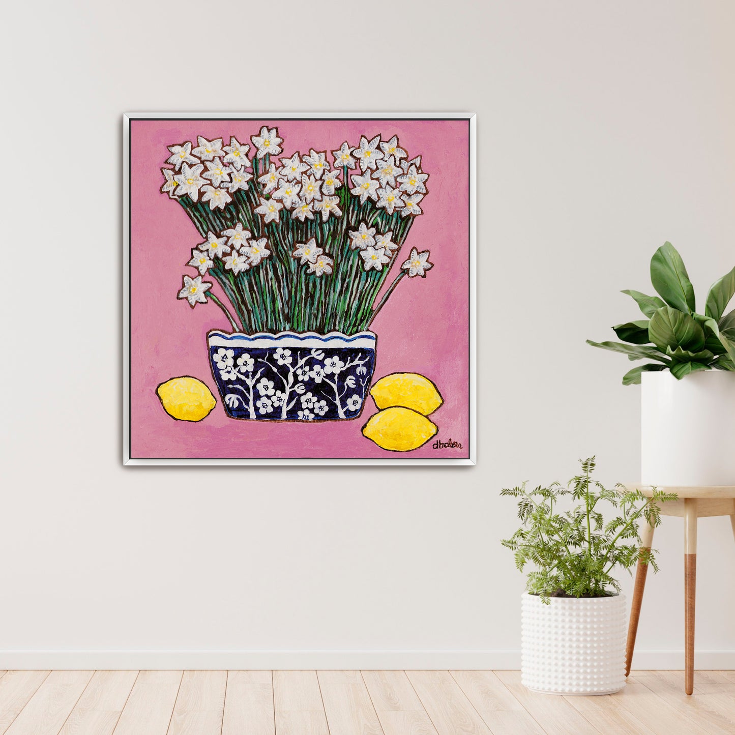 A whimsical painting of paperwhites in a blue and white floral vase surrounded by lemons against a bright pink background.