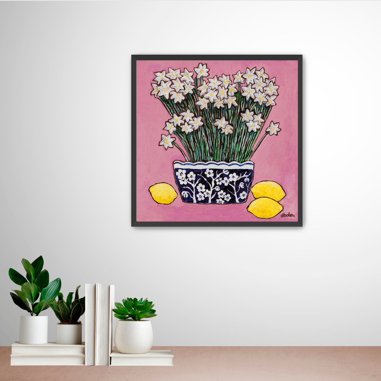 A whimsical painting of paperwhites in a blue and white floral vase surrounded by lemons against a bright pink background.
