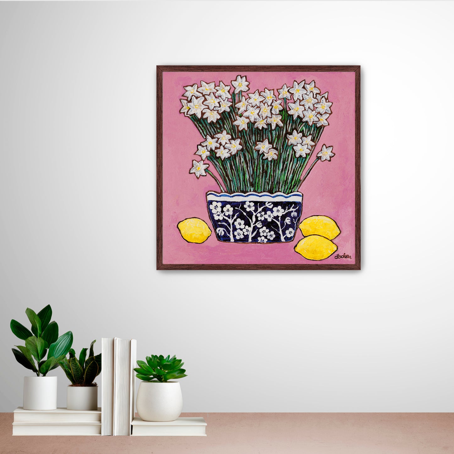 A whimsical painting of paperwhites in a blue and white floral vase surrounded by lemons against a bright pink background.
