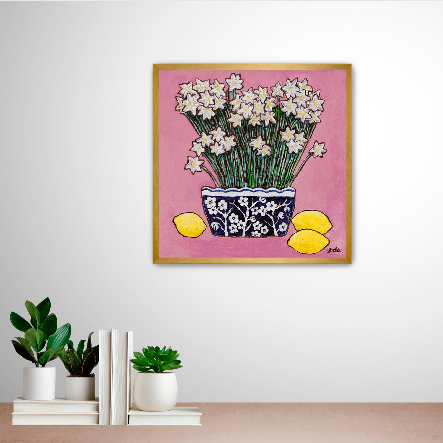A whimsical painting of paperwhites in a blue and white floral vase surrounded by lemons against a bright pink background.

