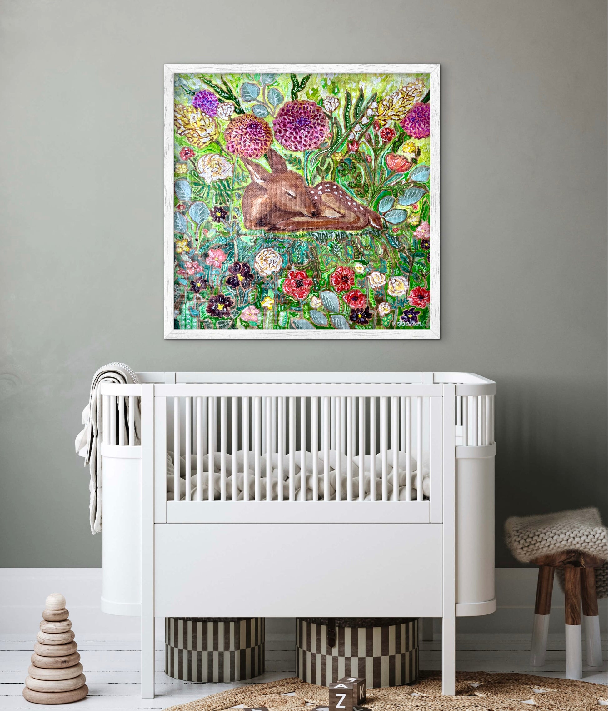 White crib in a room with a colorful painting of a deer in a floral setting on the wall. Nursery Art.
