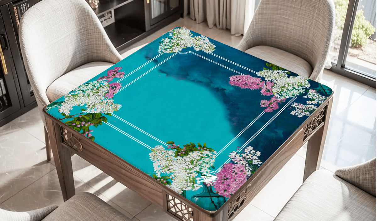 A mahjong mat featuring an original painting of a still life painting of lilacs in blue and green glass bottles.