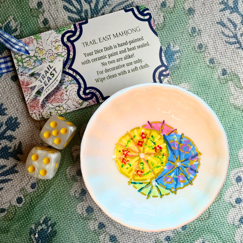 A hand painted dice dish from Trail East Studio featuring drink umbrellas to match the Party Pics Original Painting Mahjong Mat.
