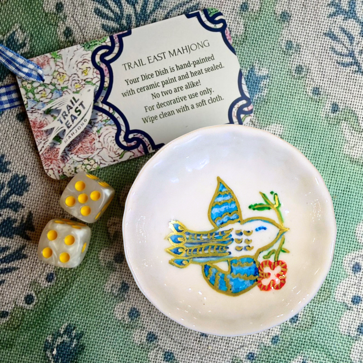 A handprinted Mahjong Dice dish featuring a bird and a red flower from Trail East Studio in Ada Michigan