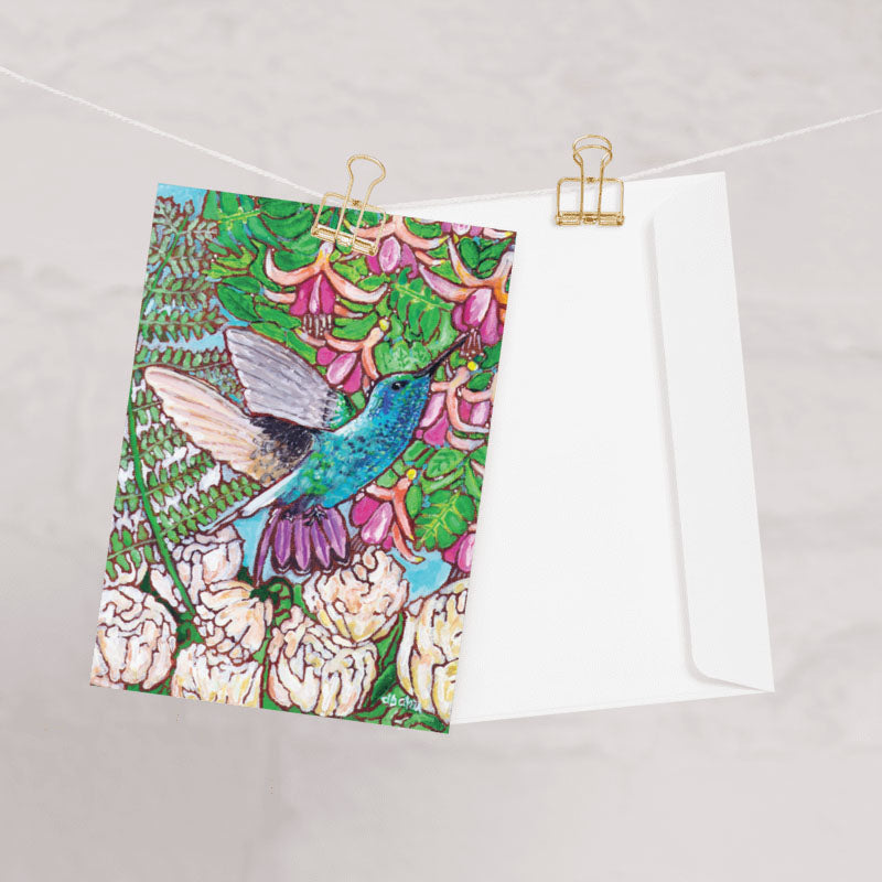 A greeting card from Trail East Studio featuring a painting of a hummingbird with peonies and fuchsia flowers